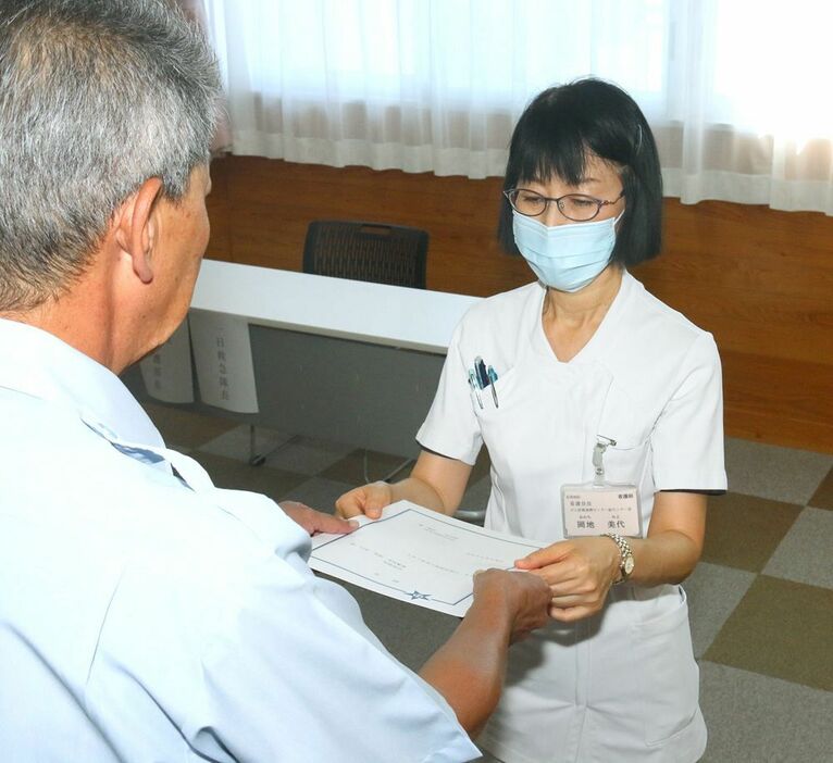 戎嶋健消防長（左）から一日救急隊長の辞令を受け取る岡地美代・紀南病院看護部長＝９日、和歌山県田辺市新庄町で