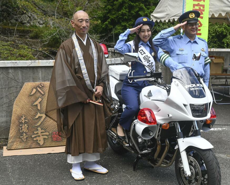 白バイと記念撮影する本瀧寺の野間秀顕副住職（左）ら＝16日午前、大阪府能勢町