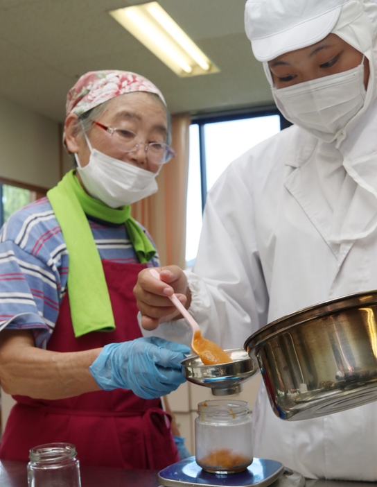 柿ジャム作りに励む氷上高校生と「生かそう丹波の食グループ」のメンバー＝兵庫県丹波市柏原町柏原で