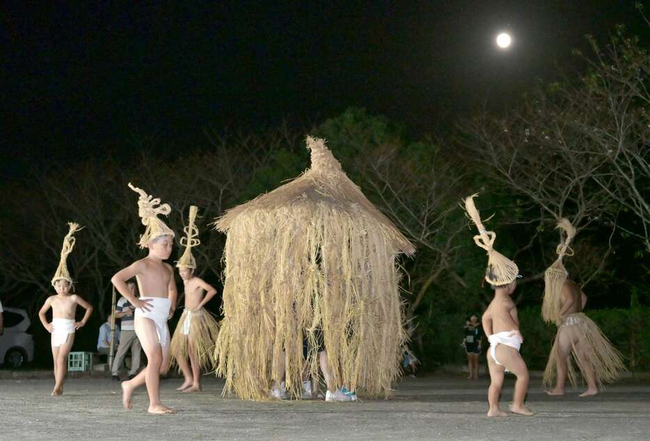 中秋の名月の下、掛け声に合わせて踊りを披露する子どもたち＝１７日午後７時２５分、南九州市知覧の中福良地区公民館