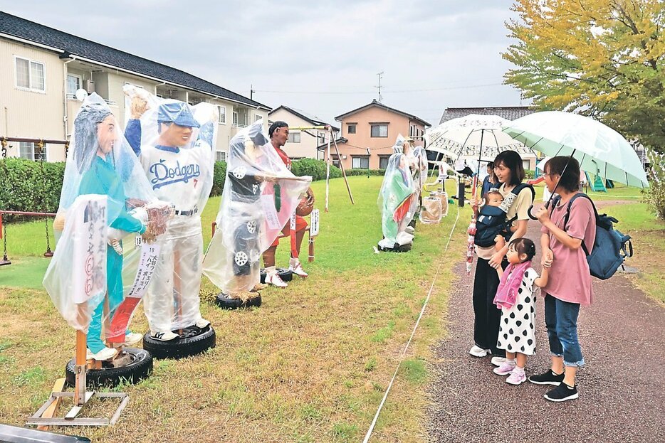 人気スポーツ選手などのかかしを見て楽しむ来場者