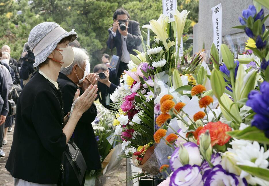 洞爺丸事故の慰霊碑前で手を合わせる遺族＝26日午前、北海道北斗市七重浜