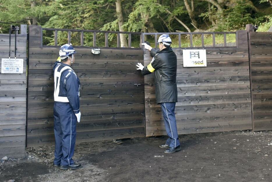 山梨県が富士山5合目に設置した「吉田ルート」の入山規制ゲートを閉鎖する警備員＝10日午後