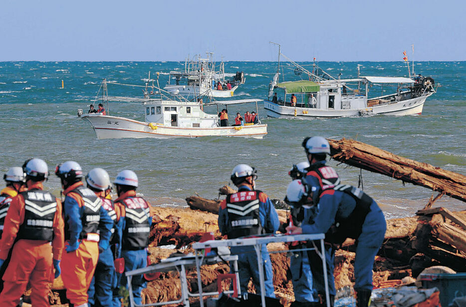 海上から喜三さんの捜索に当たる漁船（奥）＝２９日午前８時半、輪島市の塚田川河口付近