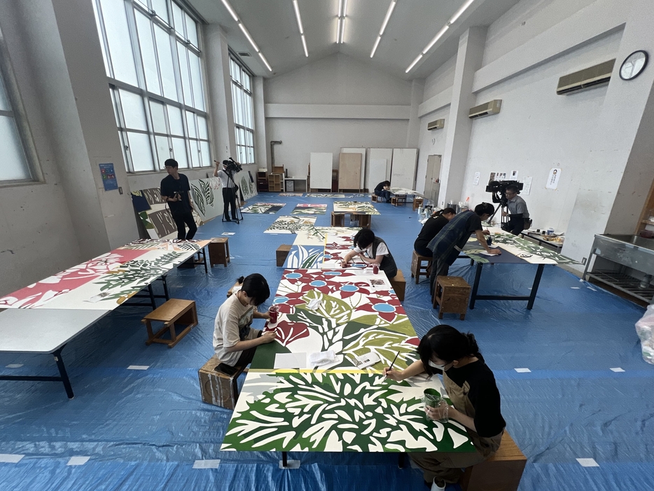 植物の描かれた16枚のパネルへの色塗り作業の風景=倉敷芸術科学大学で