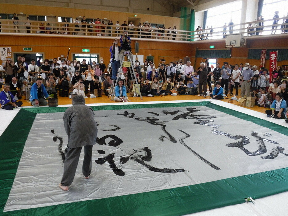 書家の高木厚人さんの揮毫を観客が見守った＝熊野町の熊野中学体育館２０２４年９月２２日午後２時７分、高田房二郎撮影