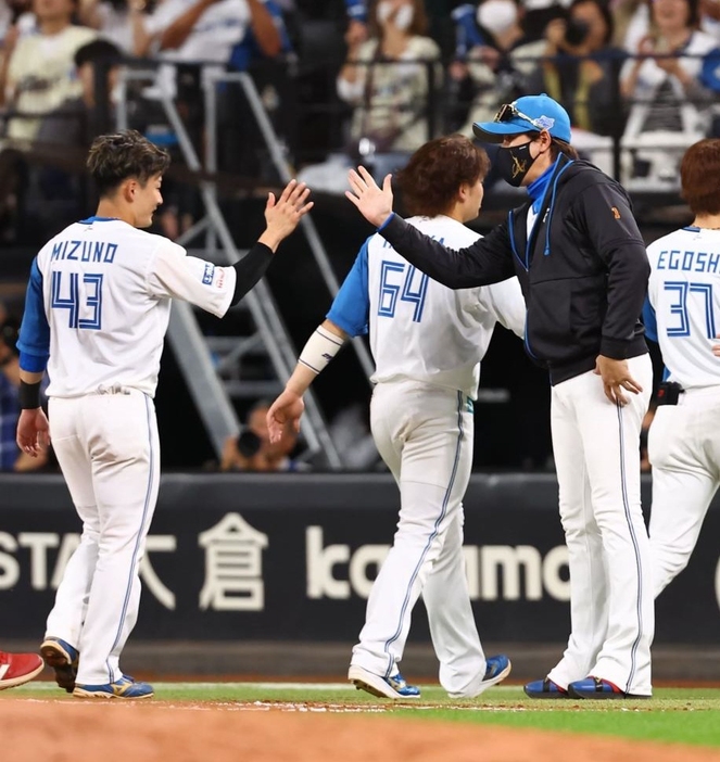 　サヨナラ勝ちでＣＳ本拠地開催を決め、水野（左から２人目）ら日本ハムナインを迎える新庄監督（中央）＝撮影・中島達哉