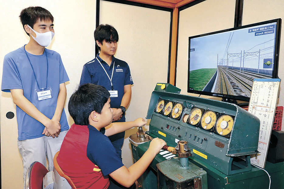 運転シミュレーターを楽しむ子ども＝小松市土居原町会館