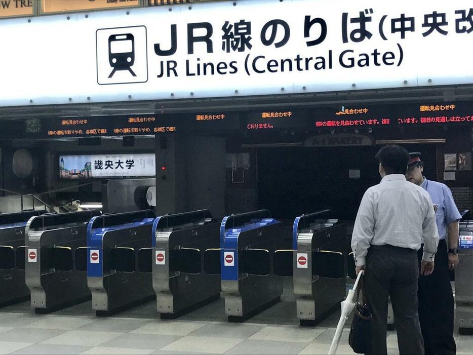 ［写真］運転見合わせとなり利用者に説明する駅員＝4日正午、大阪市内で