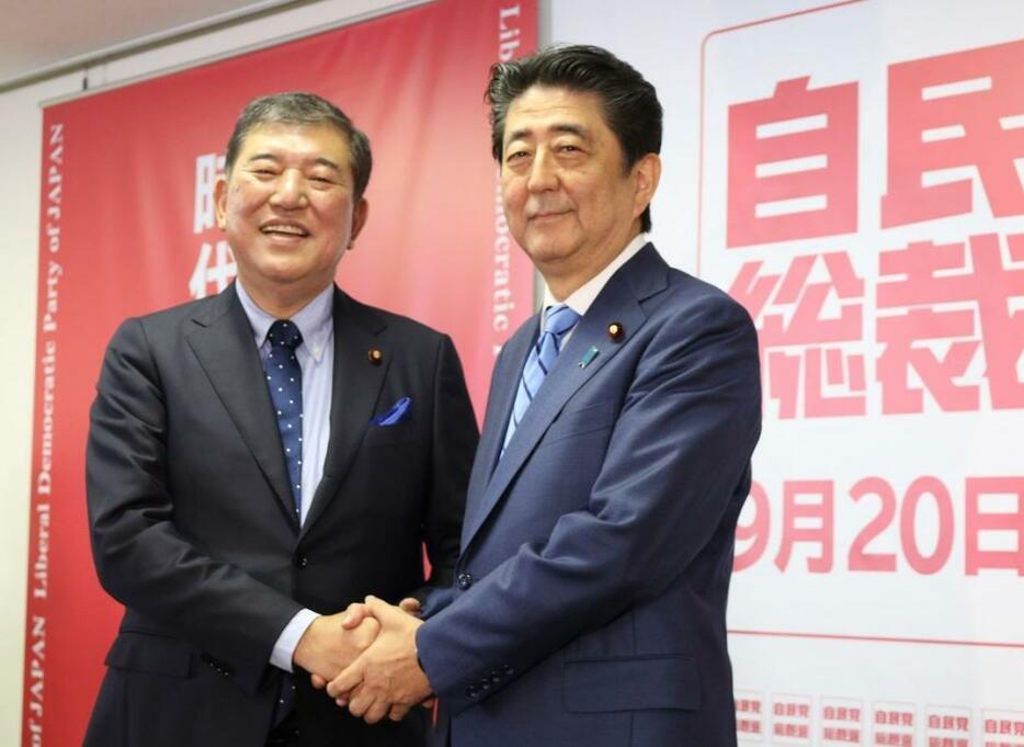 [写真]10日に行われた総裁選共同会見後に握手を交わす安倍首相（右）と石破氏