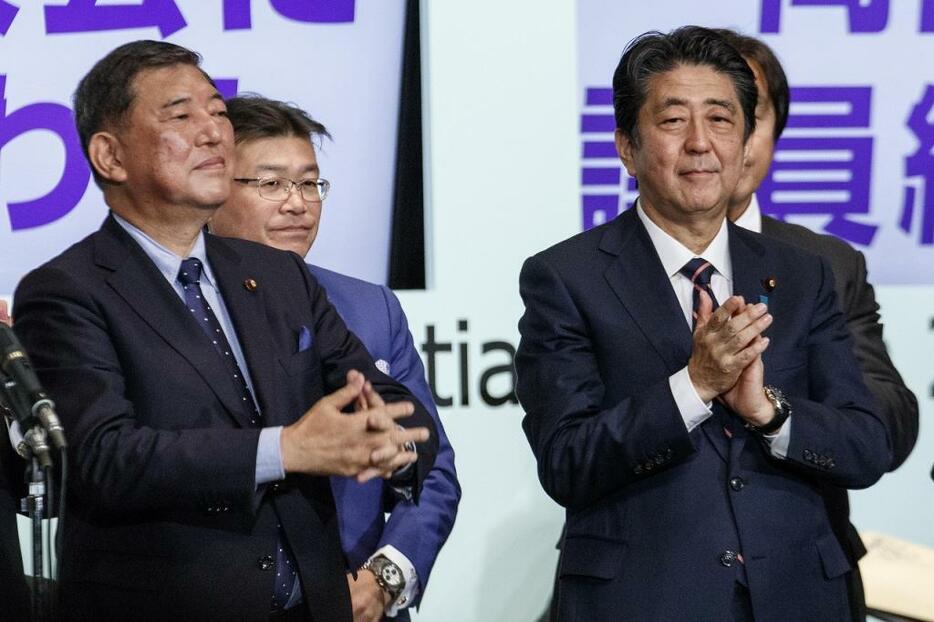 [写真]総裁選後は当選した安倍首相（右）と石破氏が壇上で握手を交わした（Rodrigo Reyes Marin/アフロ）