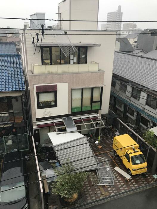 ［写真］建物の屋根や屋上の柵が強風によって飛ばされた建物＝4日午後2時すぎ、大阪市東住吉区で