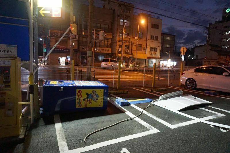[写真]ジュースの自動販売機や看板が倒れ駐車場をふさいでいた=4日午後6時すぎ、大阪市西成区で（撮影：柳曽文隆）