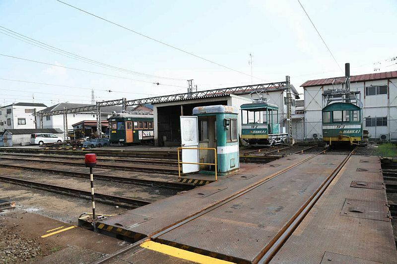 [写真]トラバーサー（右手前）は、車両を載せて、1両ごとに水平移動できる、阪堺電車ならではの設備。廃車となった車両を改造した「入換機関車」（右）も目立つ