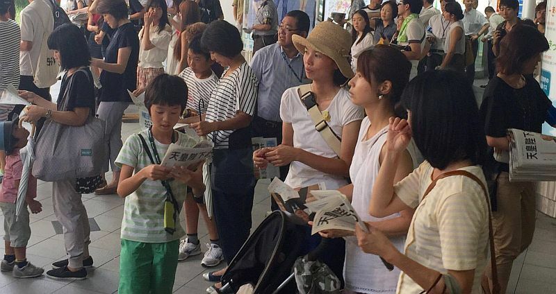 [写真]天皇陛下のお気持ち公表後、各地で号外が配られ、大阪駅前では立ち止まって記事を読む人の姿が多く見られた=8日午後3時半ごろ、大阪市北区で