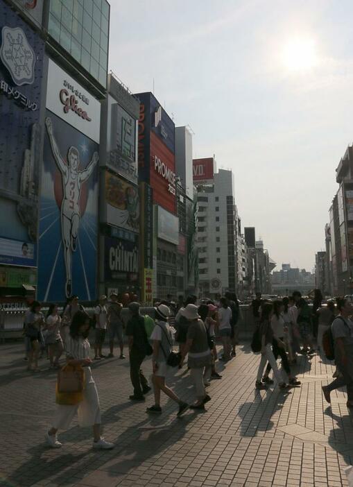 [写真]照りつける太陽のもと、戎橋ではグリコ看板と記念撮影する人も多く見られた=5日午後4時半ごろ、大阪市中央区で