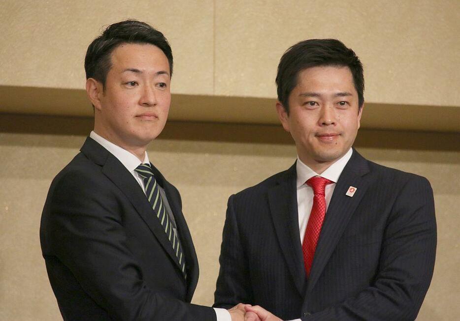 ［写真］当選確実を受け会見での写真撮影に応じる横山英幸氏（左）と吉村洋文氏＝9日午後8時40分ごろ、大阪市内で