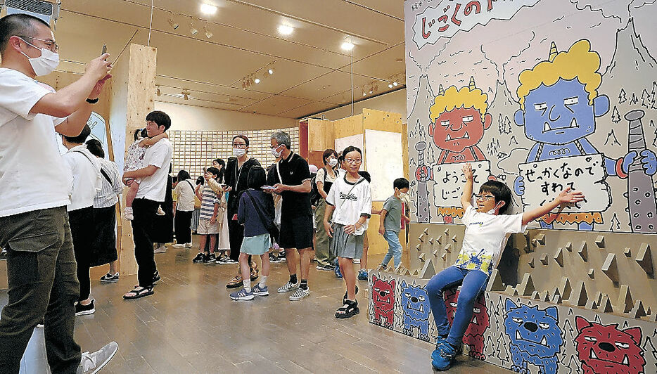 イラストが描かれたパネルの前で記念撮影する子ども＝金沢２１世紀美術館