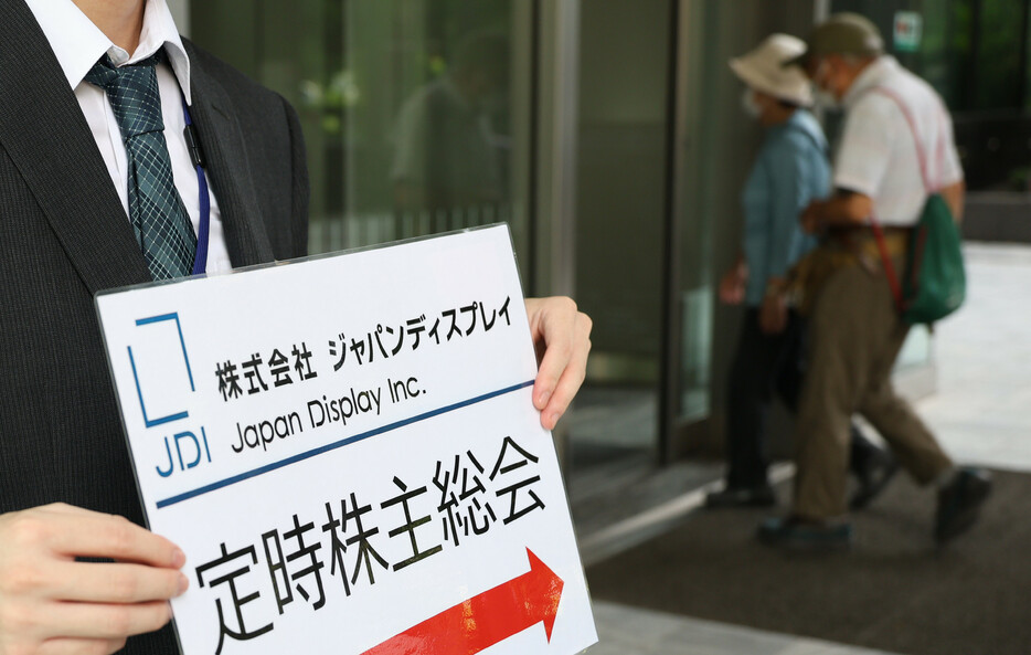 経営再建中の中小型液晶大手ジャパンディスプレイ（ＪＤＩ）は２２日、東京都内で定時株主総会を開いた。スコット・キャロン会長は冒頭、業績不振による株価の低迷について陳謝した。写真は株主総会に向かう人たち。