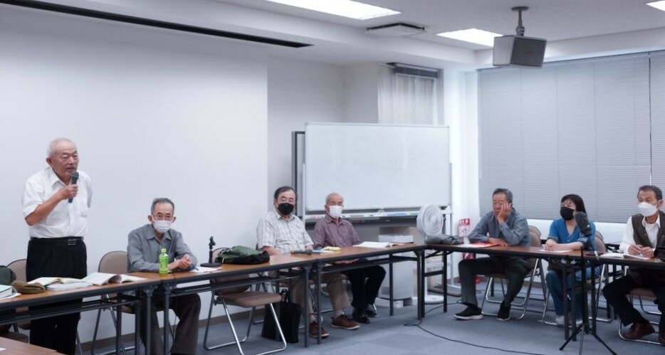 判決後の報告集会で。左から梶山正三弁護士、志村一郎原告団長と他の原告5人。（撮影／樫田秀樹）