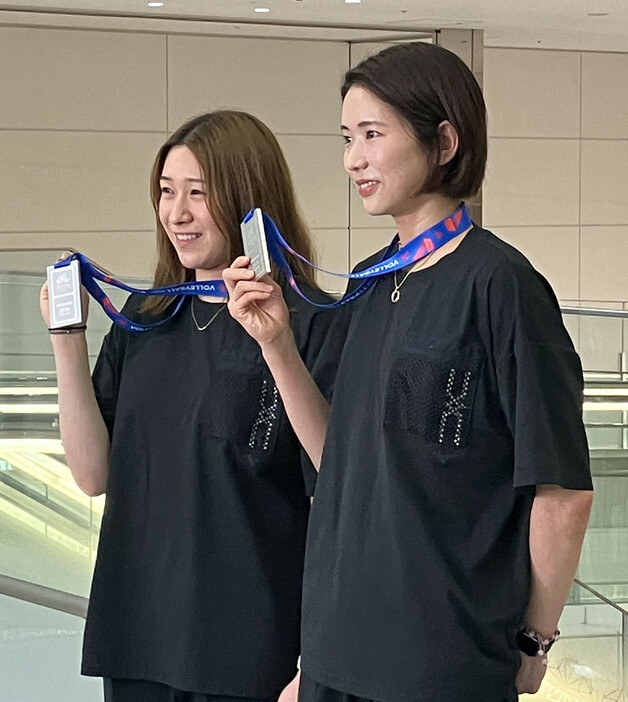 バレーボールのネーションズリーグ（ＮＬ）女子で準優勝した日本代表が２４日、バンコクから帰国した。写真は、取材に応じる古賀（右）と石川＝羽田空港