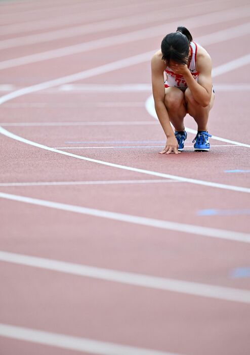 女子100メートル予選でゴールし、しゃがみ込む山形愛羽（撮影・中村太一）
