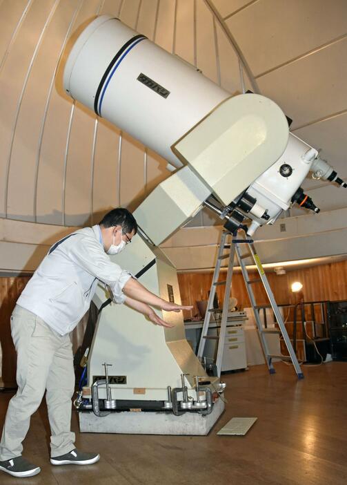 大型天体望遠鏡の破損部分を説明する学芸員の宇佐美拓也さん＝8日午前、石川県能登町