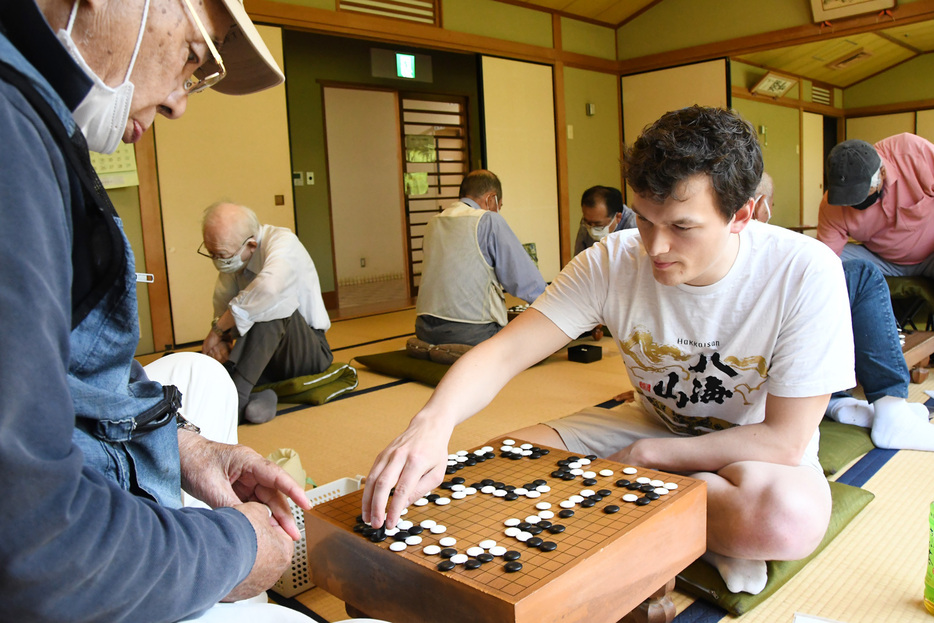 真剣な表情で碁を打つパトリックさん＝館山