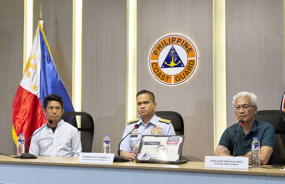 7日、マニラで記者会見するフィリピン沿岸警備隊のタリエラ報道官（中央）と海洋環境調査を行った科学者ら（共同）