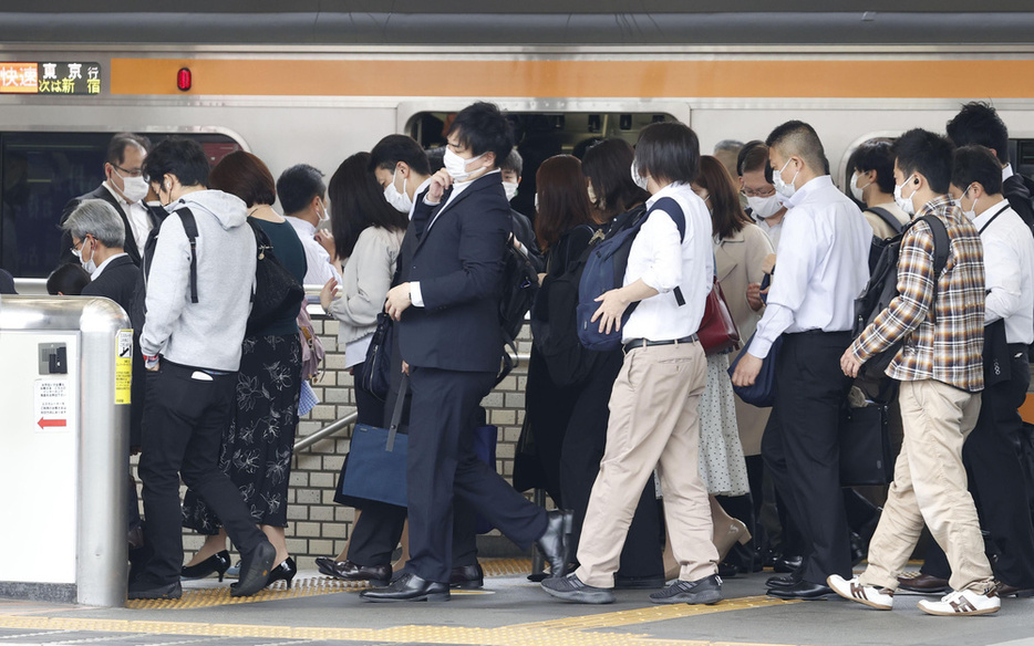 通勤客らで混み合う東京の駅のホーム＝2021年5月、東京都中野区
