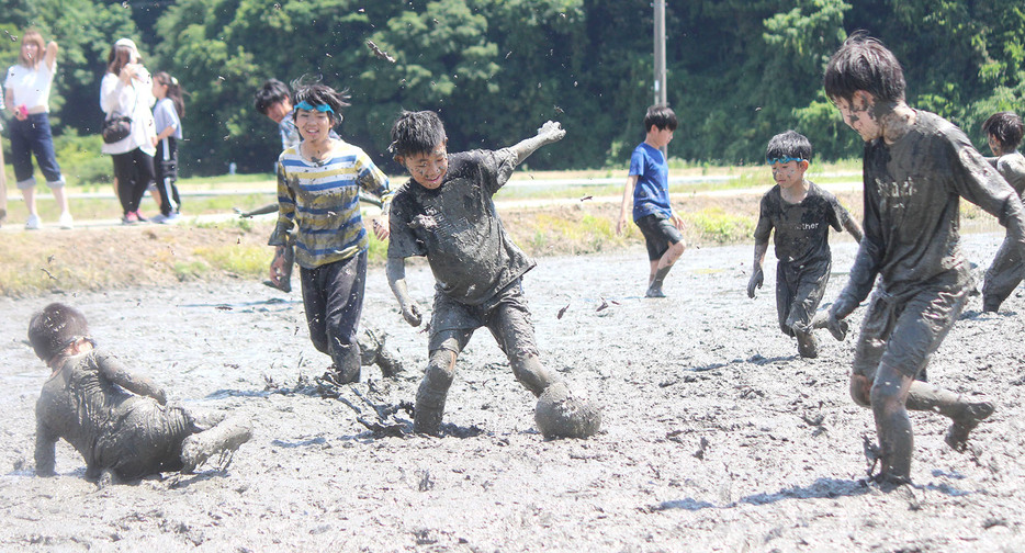泥だらけになりながらサッカーを楽しむ子供たち＝丹生寺町で