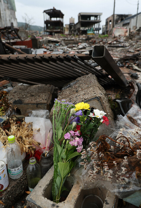 能登半島地震の発生から１日で半年を迎える。写真は、地震により焼失した朝市通り周辺に供えられた花＝３０日午前、石川県輪島市