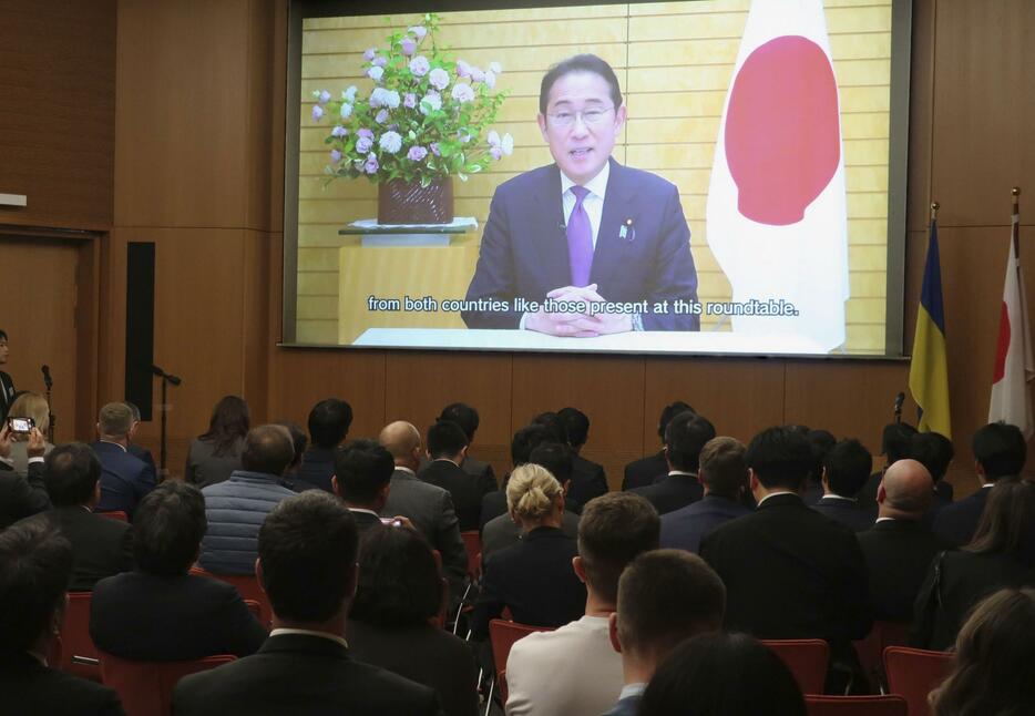 会合で岸田首相の動画メッセージを聞く参加者ら＝10日、ベルリン（共同）