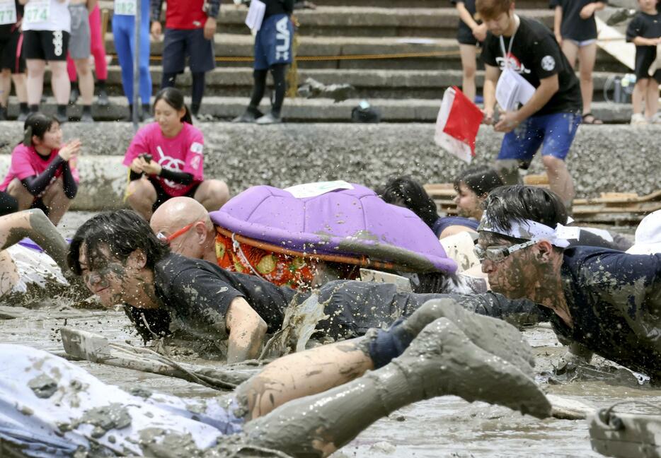 「鹿島ガタリンピック」で、泥だらけになって競技する「人間むつごろう」の参加者＝2日午後、佐賀県鹿島市