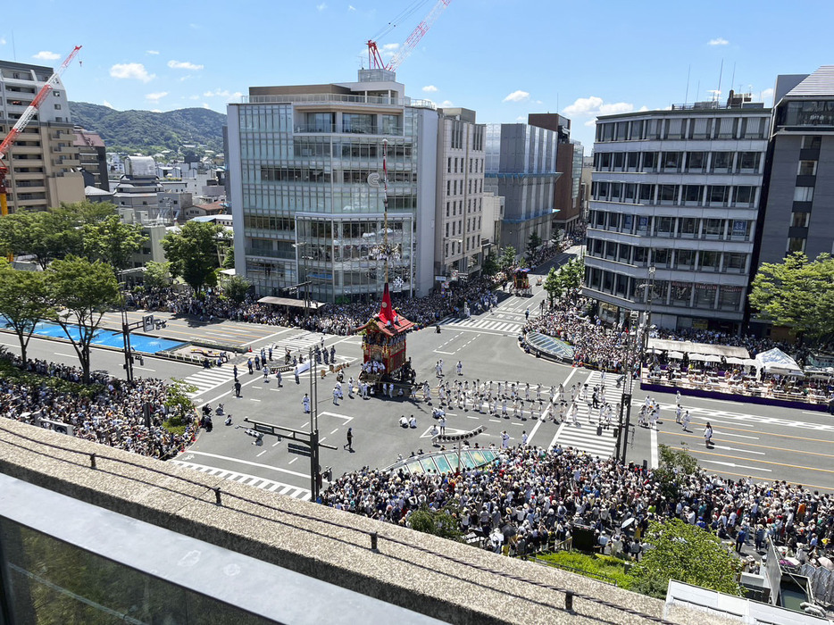 京都市役所本庁舎の屋上庭園から見た祇園祭の山鉾巡行＝2023年7月