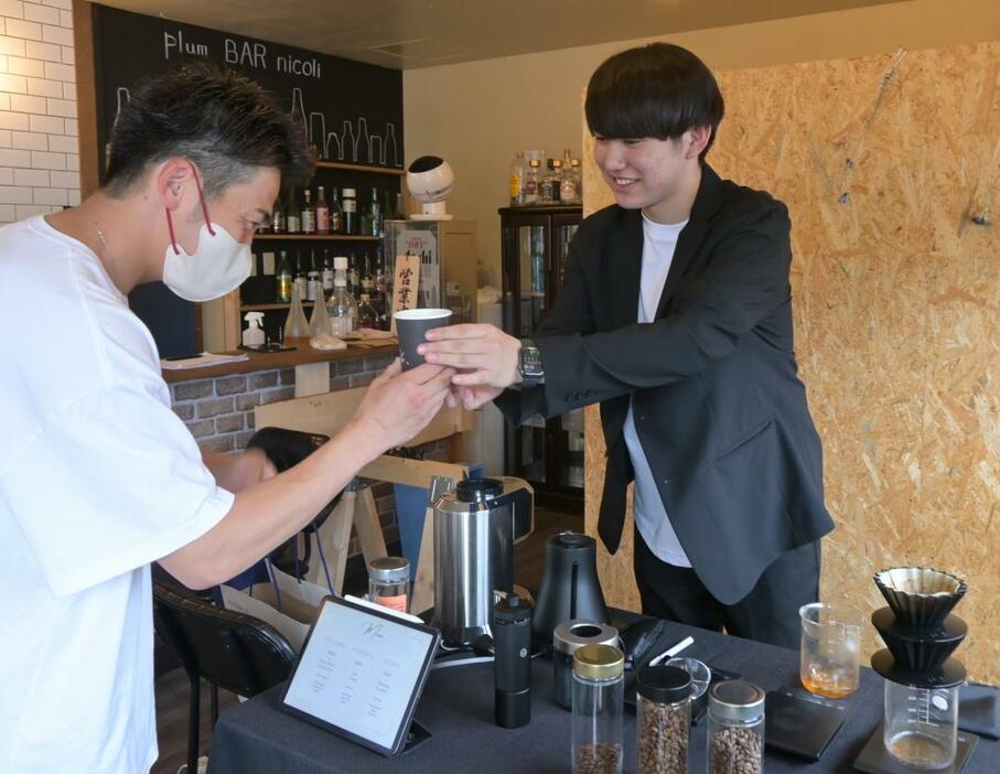 安価なスペシャルティコーヒーの提供をを始めた八周岳さん(右)=水戸市中央