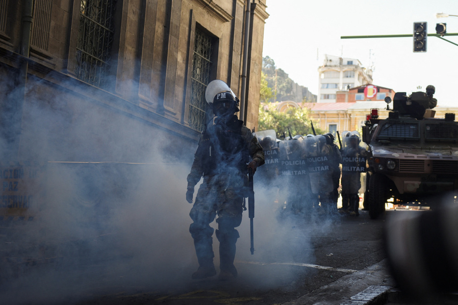　南米ボリビアで２６日、一部の軍部隊がラパスの中央広場を占拠し、装甲車で大統領官邸の入り口に突っ込んだ。左派のアルセ大統領は政府に対する「クーデター」と非難し、国際的な支援を呼びかけた。写真は催涙ガスの中を歩く治安部隊（２０２４年　ロイター/Claudia Morales）