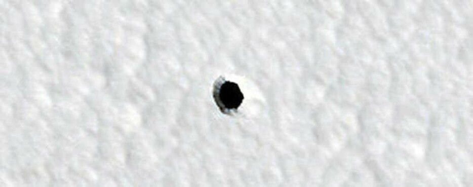 NASAの火星探査機「マーズ・リコネッサンス・オービター」に搭載されたHiRISEカメラが2022年に撮影したこの写真により、火星の「謎めいた穴」をめぐる議論が再燃している。