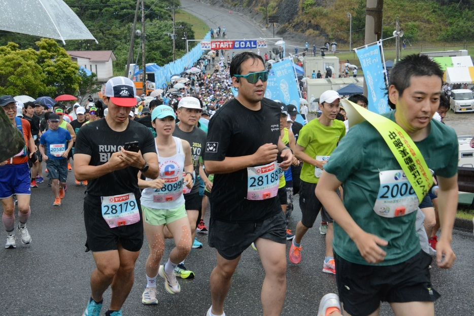 雨の中で健脚を競うハーフマラソンのランナーたち