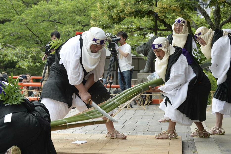 鞍馬寺の「竹伐り会式」で、大蛇に見立てた青竹をたたき切る僧兵姿の男性ら＝20日午後、京都市左京区