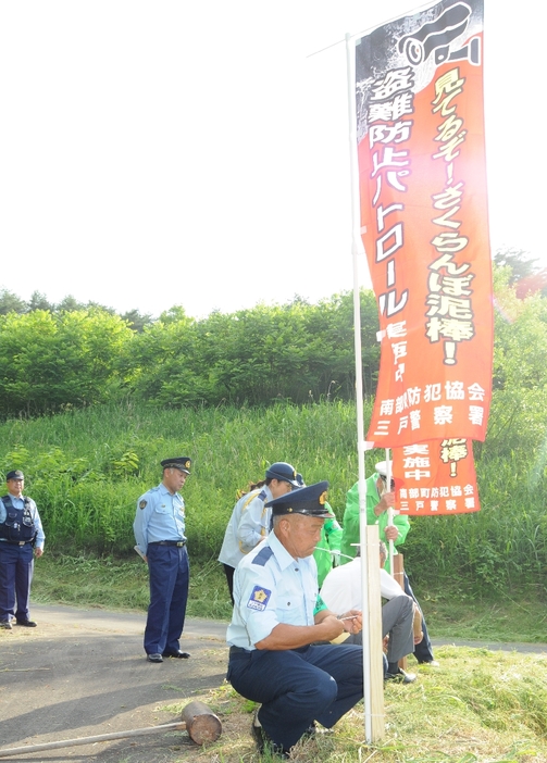 監視活動を伝えるのぼり旗を設置する参加者