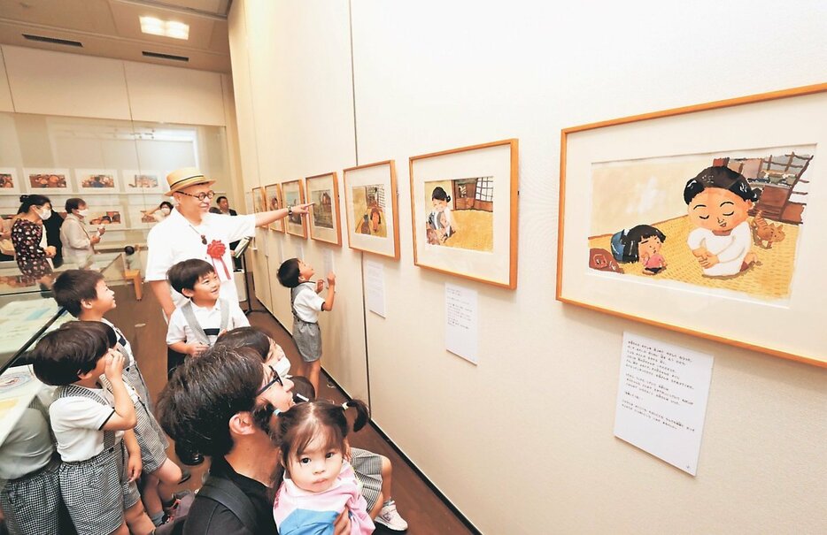 「しげちゃん」の原画が並ぶ一角。開会式後、帽子をかぶった長谷川さんが子どもたちと見て回った＝高志の国文学館
