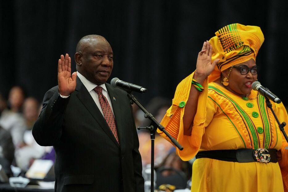 14日に招集された南アフリカ議会で宣誓するラマポーザ大統領（左）＝ケープタウン（ロイター＝共同）