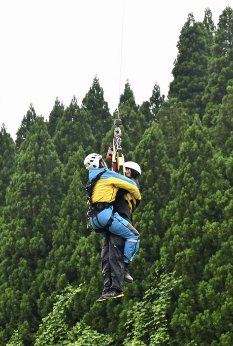 ヘリコプターで取り残された被災者役の警察官をつり上げる訓練＝24日午前、富山県氷見市
