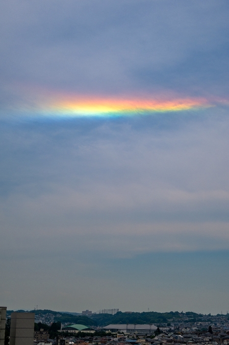 南の空に浮かんだ「環水平アーク」とみられる虹色の帯＝22日午後0時35分ごろ、八戸市のデーリー東北新聞社屋上