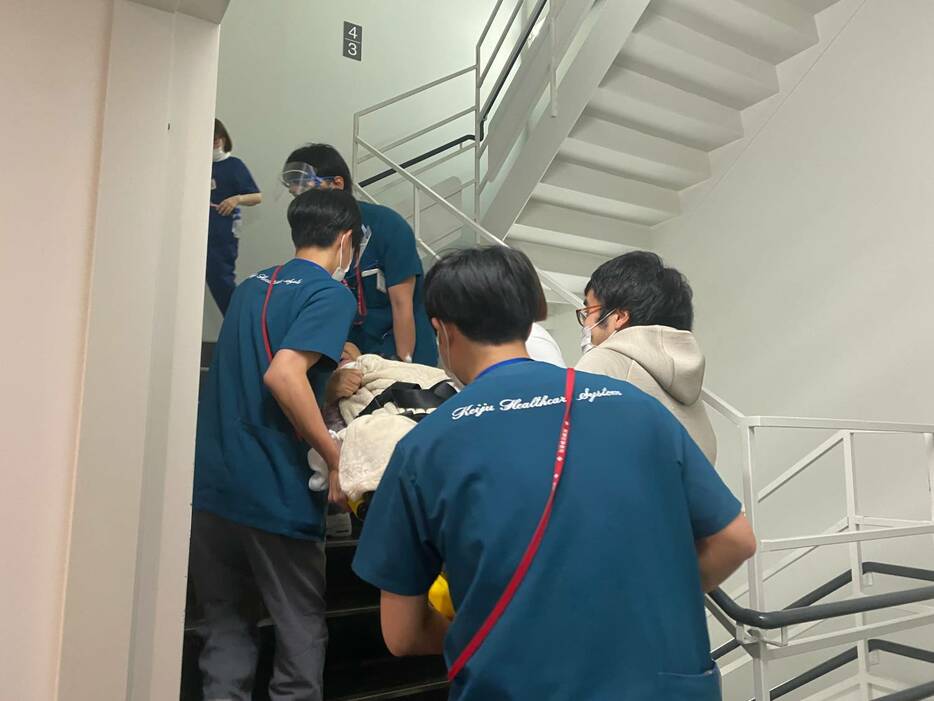 地震当日に耐震病棟から安全な免震病棟へ患者を移動させる職員ら
