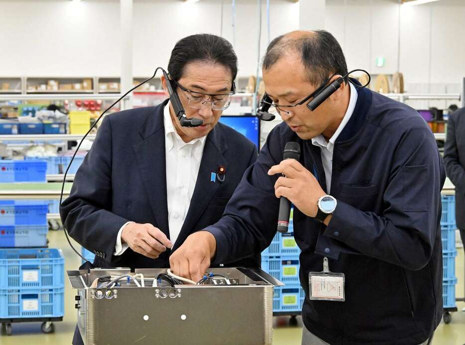 視察した山梨県韮崎市の工場でスマートグラスの説明を受ける岸田文雄首相（左）＝２９日午後（代表撮影）