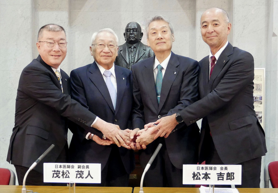 2選を決め、写真撮影に応じる日本医師会の松本吉郎会長（右から2人目）ら＝22日、東京都文京区