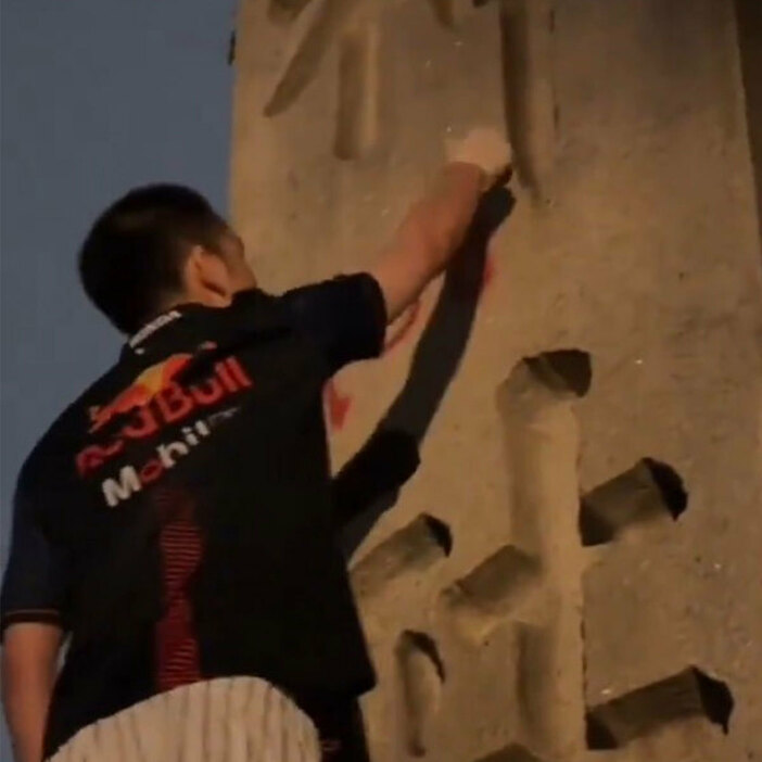 靖国神社の石柱に落書きする男（中国のSNSより）