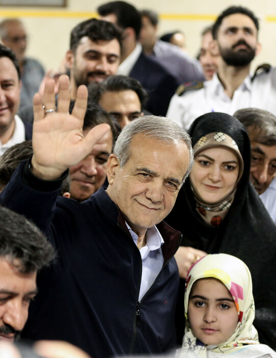 ２８日、テヘランで、イラン大統領選の投票所に到着した改革派のペゼシュキアン元保健相（中央）。